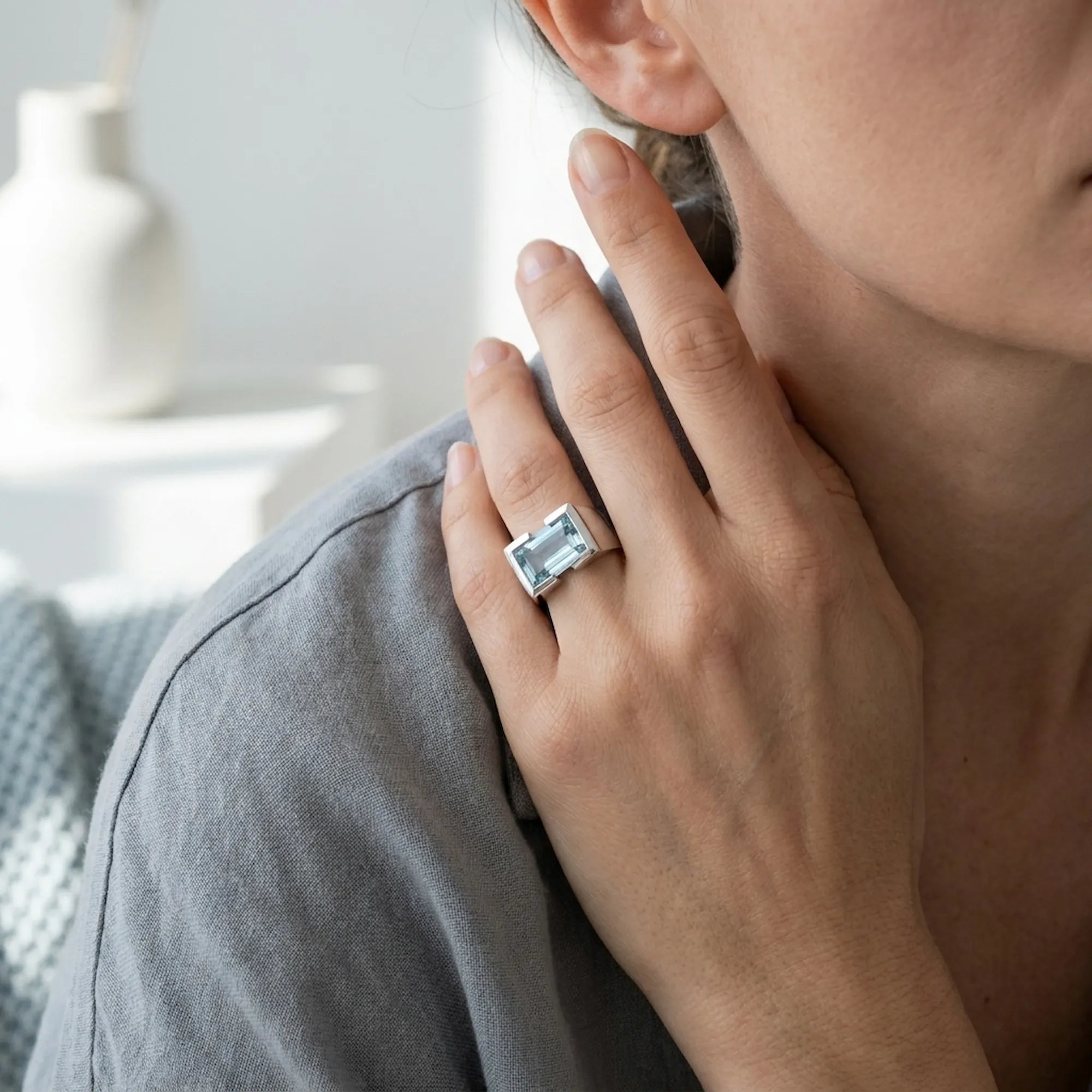 Sky blue topaz ring worn on hand — 925 silver architectural statement ring, natural stone, neutral home background