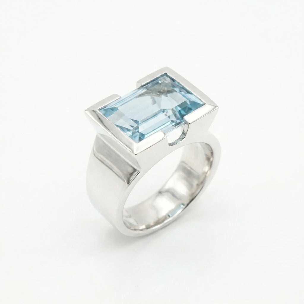 Architectural sky blue topaz statement ring on white background — 8.15ct natural topaz in 925 silver half-bezel, angled view