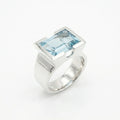 Architectural sky blue topaz statement ring on white background — 8.15ct natural topaz in 925 silver half-bezel, angled view