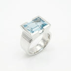 Architectural sky blue topaz statement ring on white background — 8.15ct natural topaz in 925 silver half-bezel, angled view