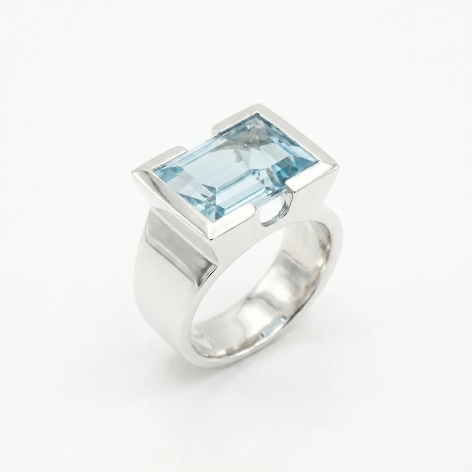 Architectural sky blue topaz statement ring on white background — 8.15ct natural topaz in 925 silver half-bezel, angled view