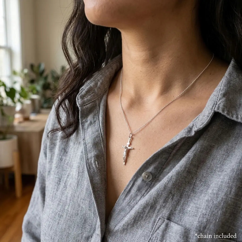 Small 925 sterling silver crucifix necklace worn by a woman.