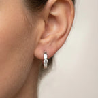 Solitaire Cubic Zirconia huggie earring close on the lobe, side view — 925 sterling silver clicker hoop, rhodium finish