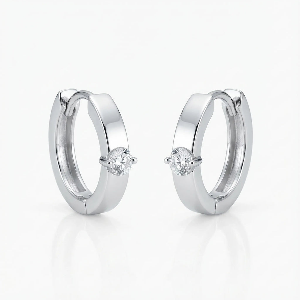 Solitaire Cubic Zirconia huggie earrings in rhodium 925 sterling silver on white background — clicker hoop, front-set stone