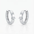 Solitaire Cubic Zirconia huggie earrings in rhodium 925 sterling silver on white background — clicker hoop, front-set stone