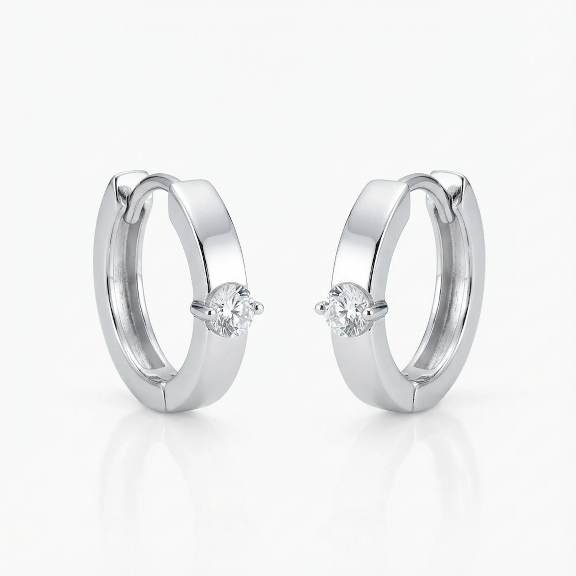 Solitaire Cubic Zirconia huggie earrings in rhodium 925 sterling silver on white background — clicker hoop, front-set stone