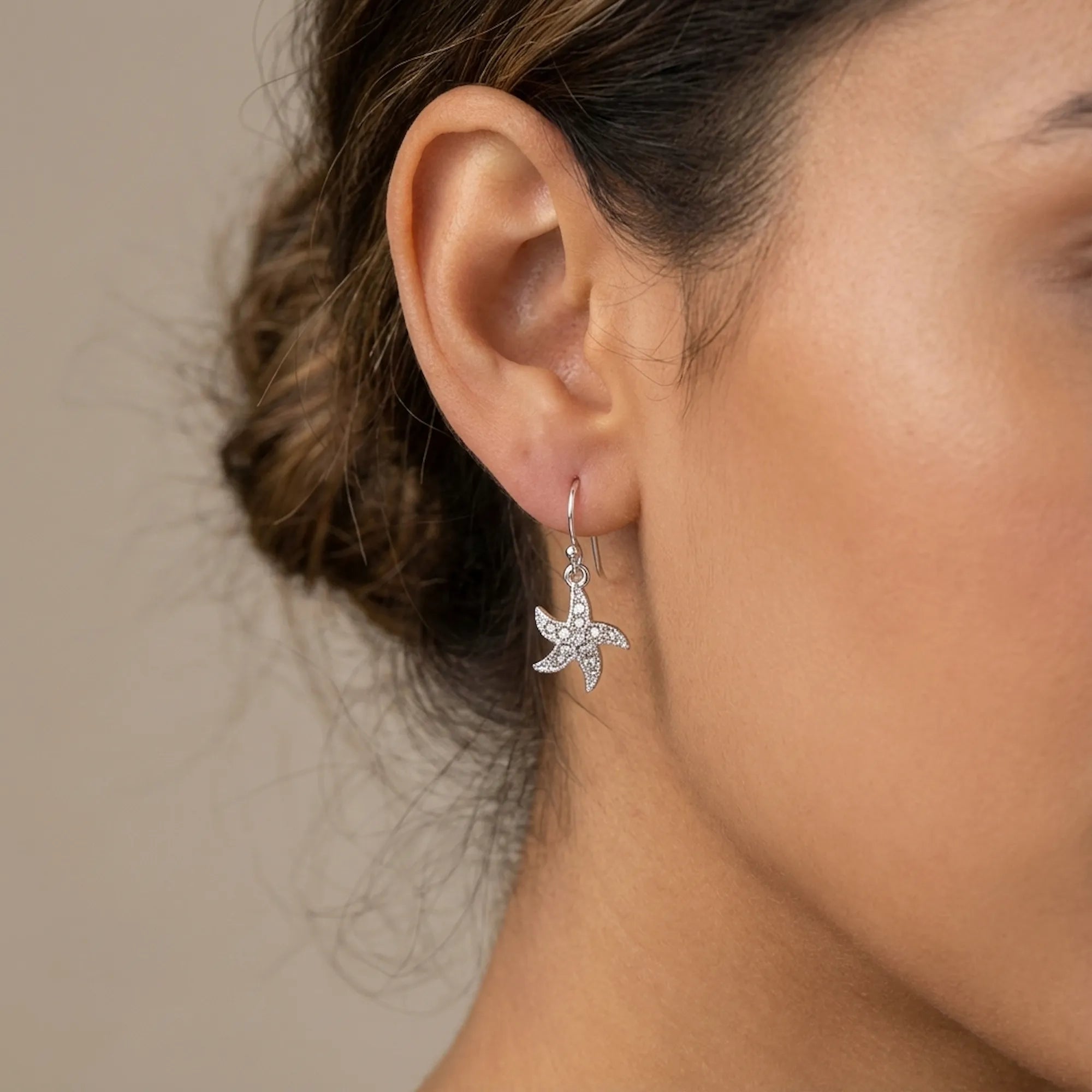 Pave cubic zirconia starfish drop earring worn on the ear, rhodium-plated 925 sterling silver, Dubai UAE