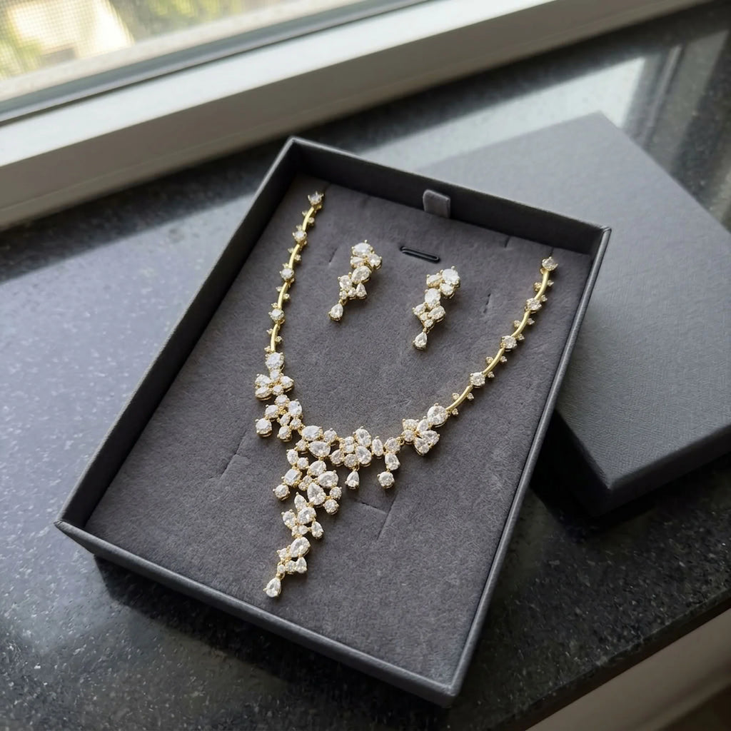18k gold-plated cubic zirconia waterfall necklace and earring set presented in a luxury dark grey gift box in Dubai.