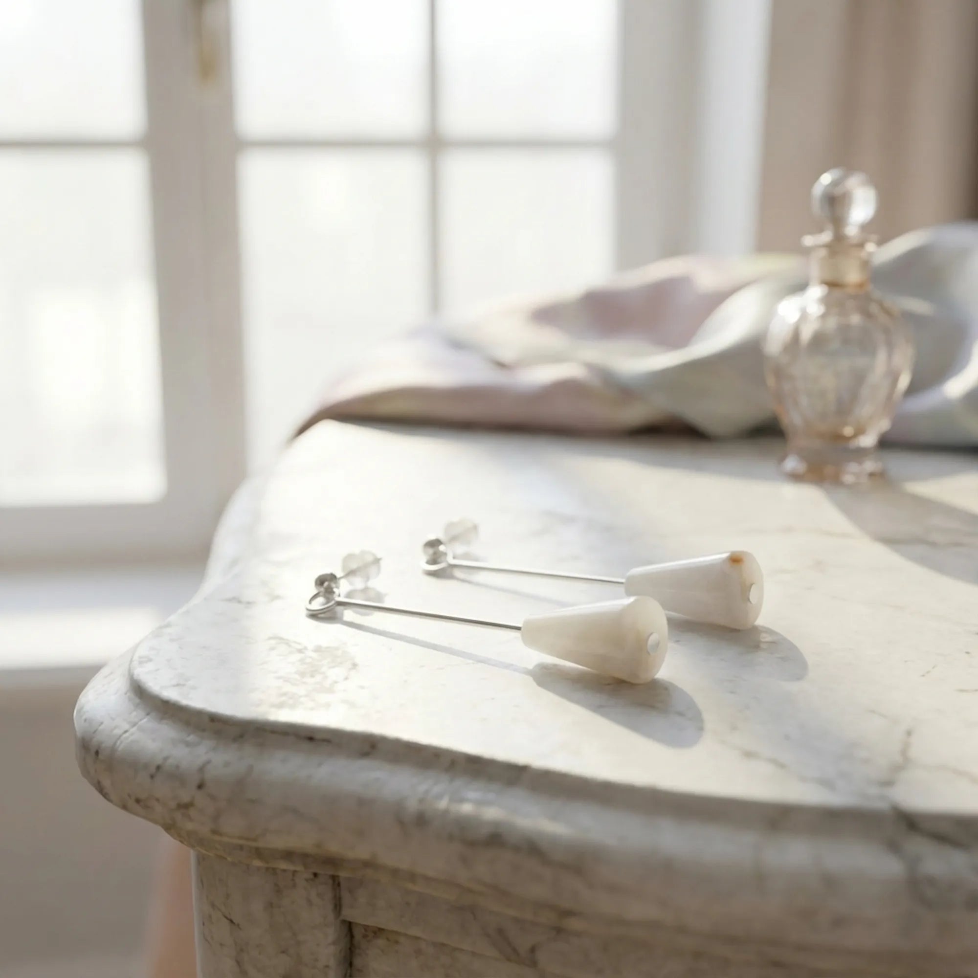 Sunset Onyx silver drop earrings on a marble vanity with perfume, minimalist styling, Luna Dura Dubai