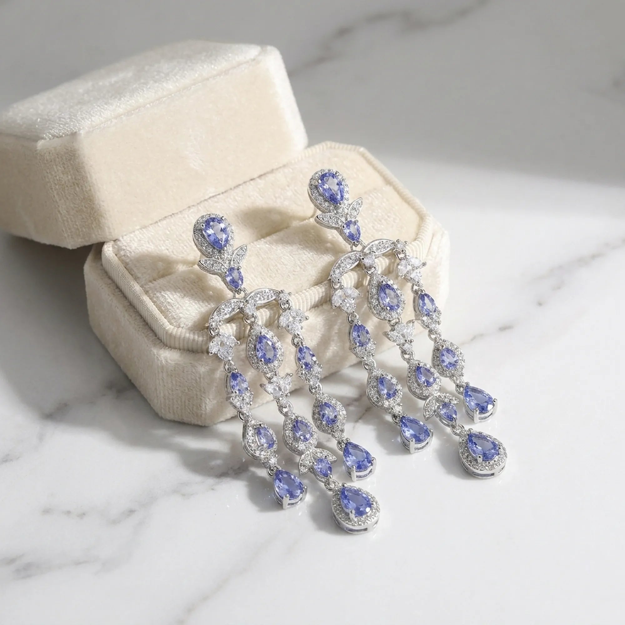 Tanzanite chandelier earrings in a cream velvet gift box, rhodium-plated 925 silver, Luna Dura Dubai.