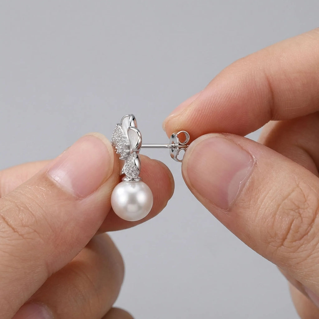 Fingers demonstrating how to attach the secure butterfly back earrings.