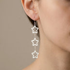 925 sterling silver triple star drop earrings worn on model ear with three open star frames on a box chain