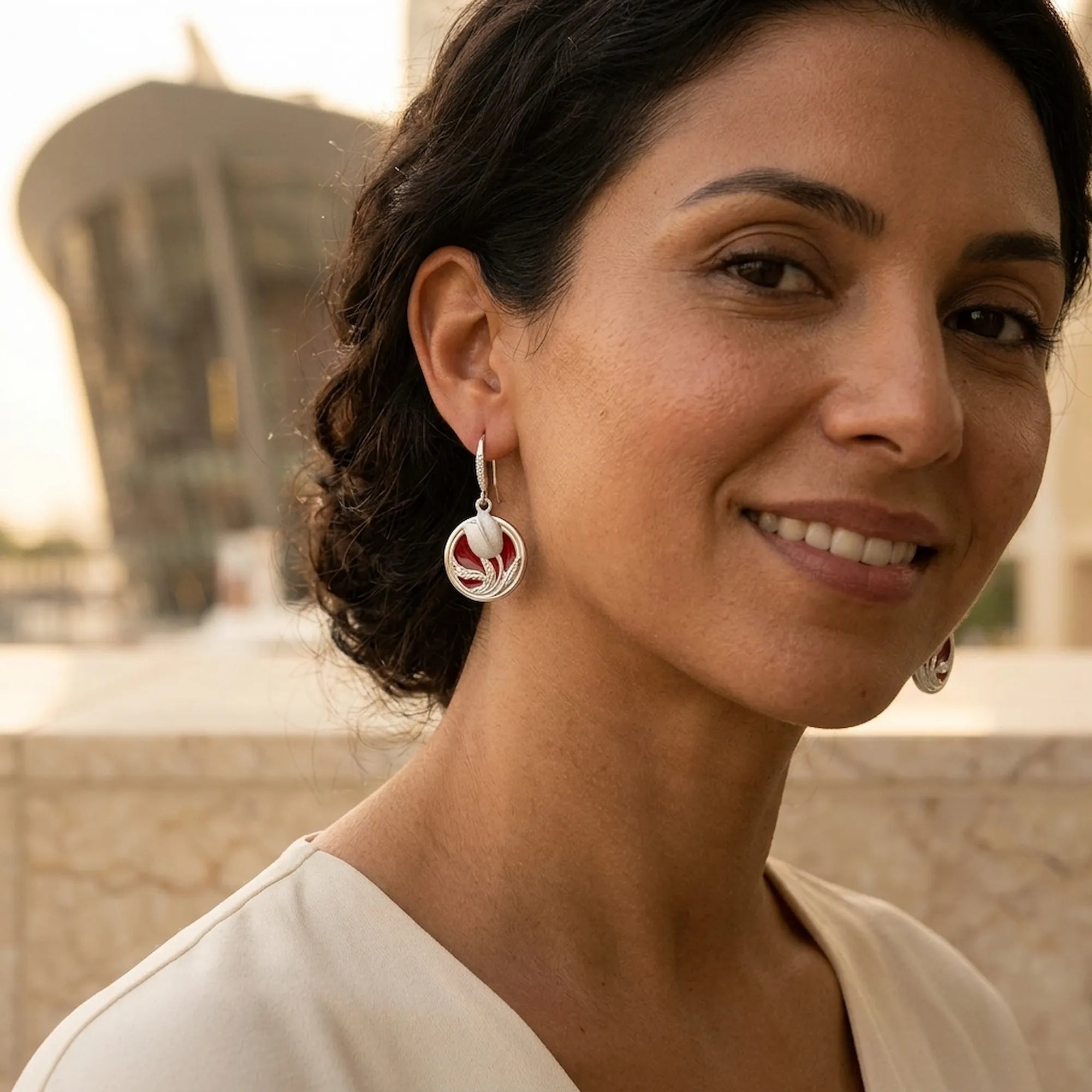 Red enamel tulip drop earring in 925 sterling silver worn on model with Dubai Opera visible in background