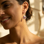 Red enamel tulip drop earring in 925 sterling silver worn on model in outdoor warm heritage setting