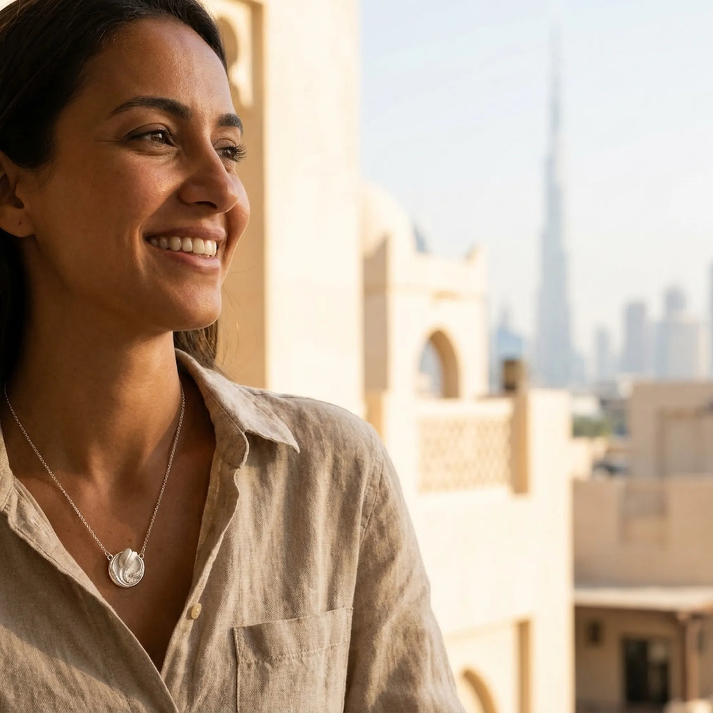 Model wearing tulip medallion necklace with Burj Khalifa Dubai skyline — 925 silver sculpted pendant at collarbone
