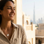 Model wearing tulip medallion necklace with Burj Khalifa Dubai skyline — 925 silver sculpted pendant at collarbone