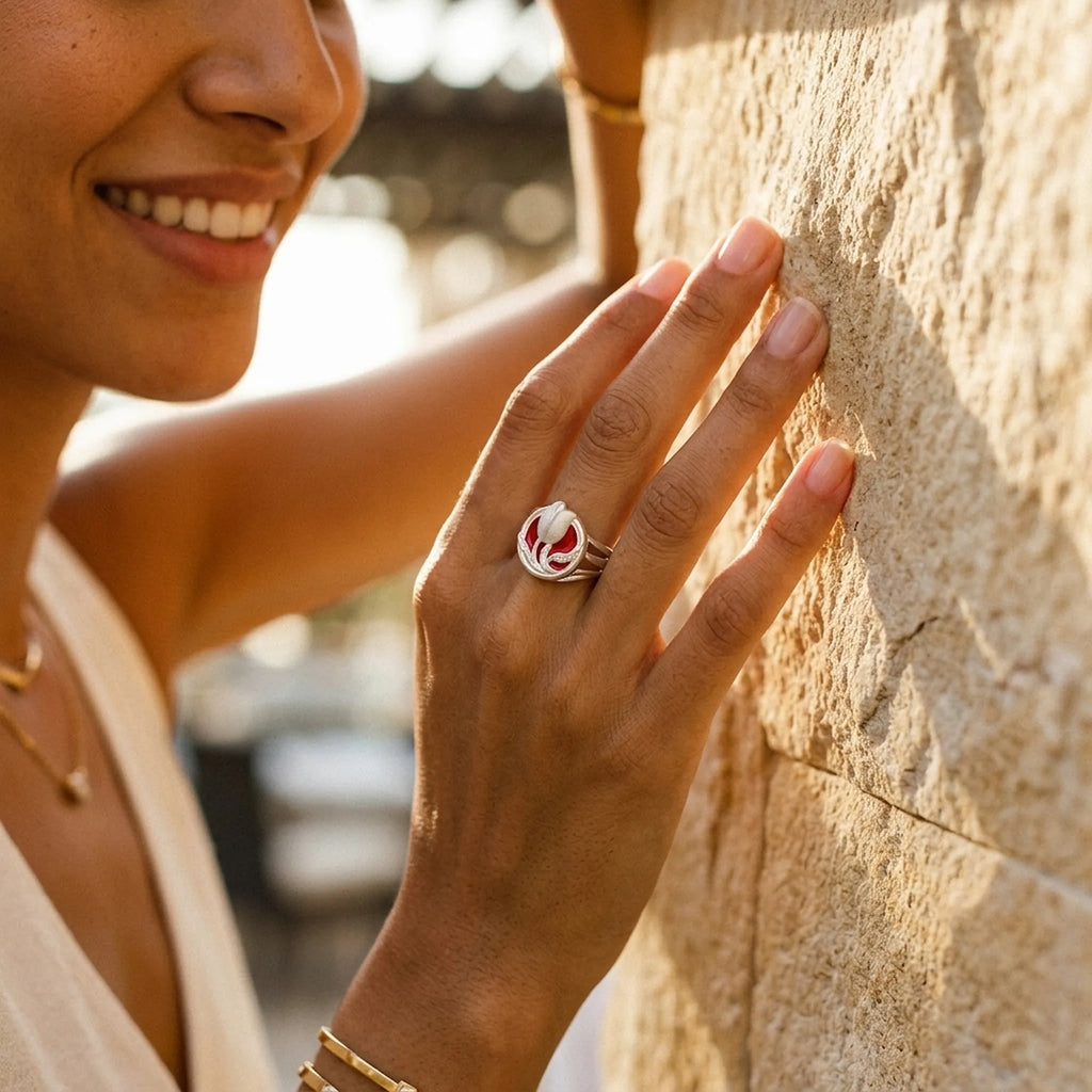 Satin silver tulip medallion ring on model hand with coffee cup and Dubai skyline through window