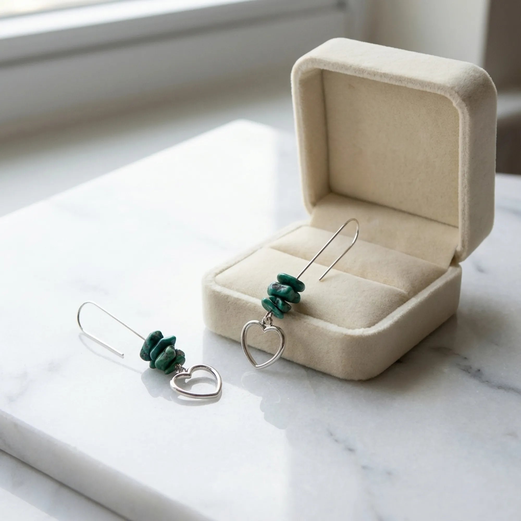 Turquoise chip and heart silver drop earrings beside open cream velvet gift box on marble — gifting presentation