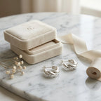 Twisted 925 silver hoop earrings beside cream velvet gift box on marble — gifting presentation, Dubai