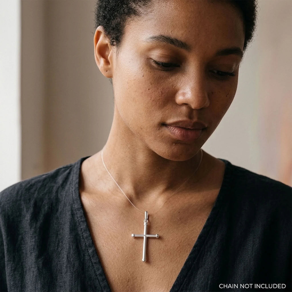Woman wearing a polished 925 sterling silver tubular cross pendant, chain not included.