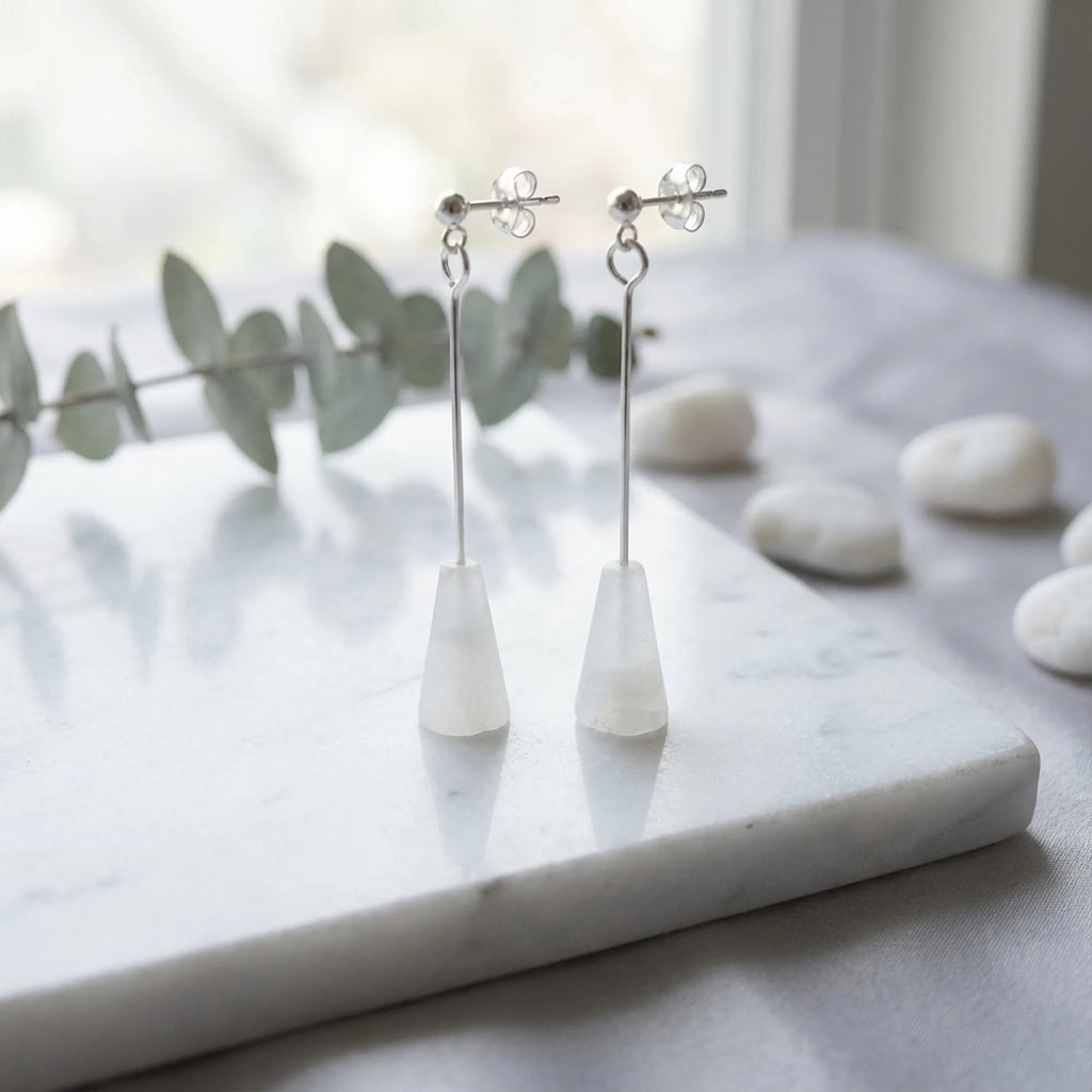 White stone silver drop earrings on marble with eucalyptus, minimalist styling, Luna Dura Dubai