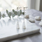 White stone silver drop earrings on marble with eucalyptus, minimalist styling, Luna Dura Dubai