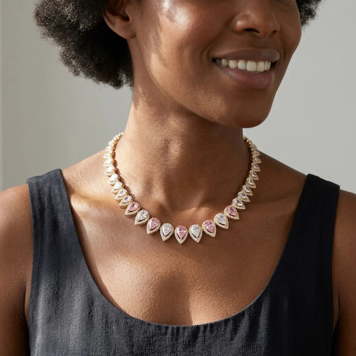 Woman wearing an 18k gold plated choker with alternating blush pink and white teardrop cubic zirconia in Dubai.