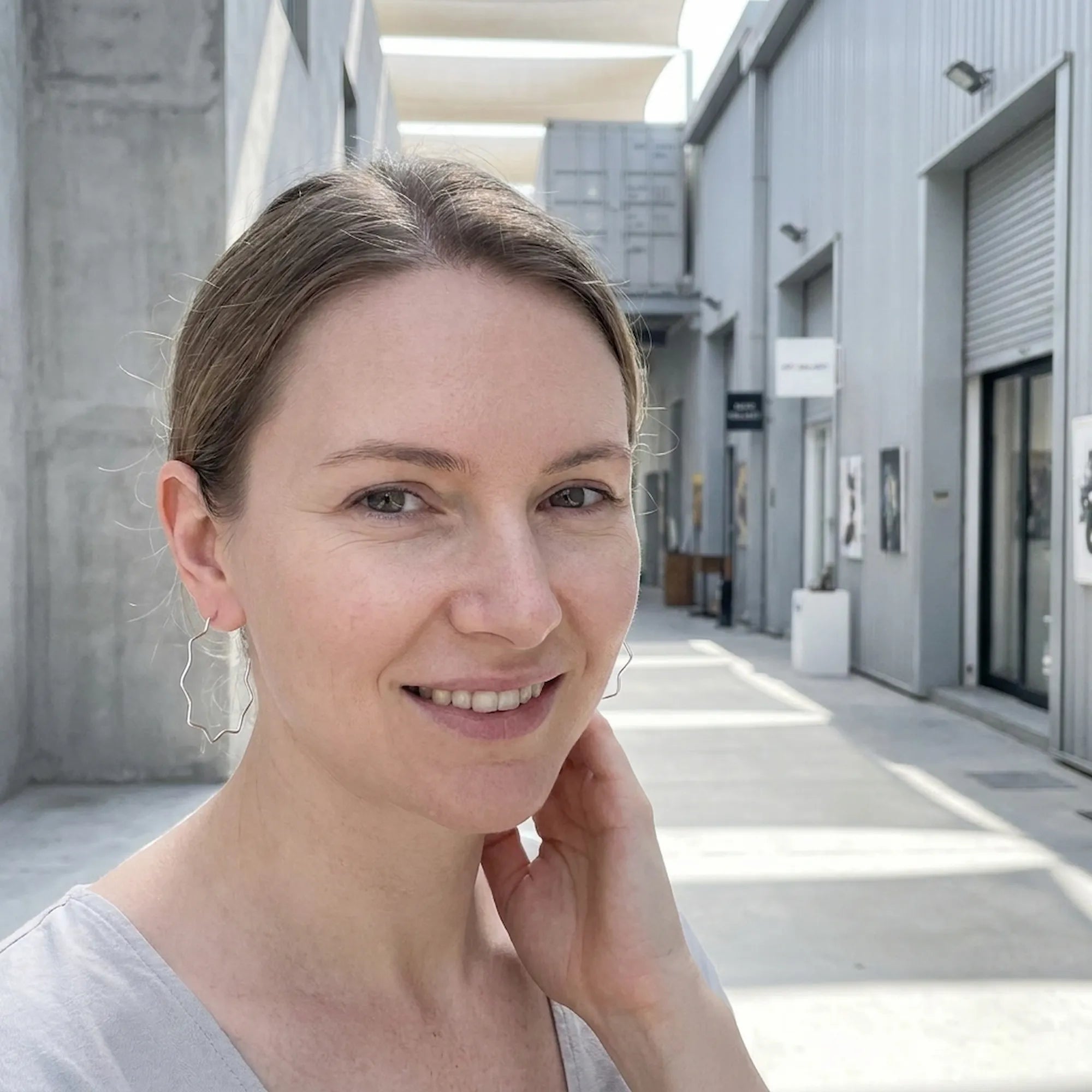 Model wearing large silver zigzag geometric hoops at Alserkal Avenue, Dubai.
